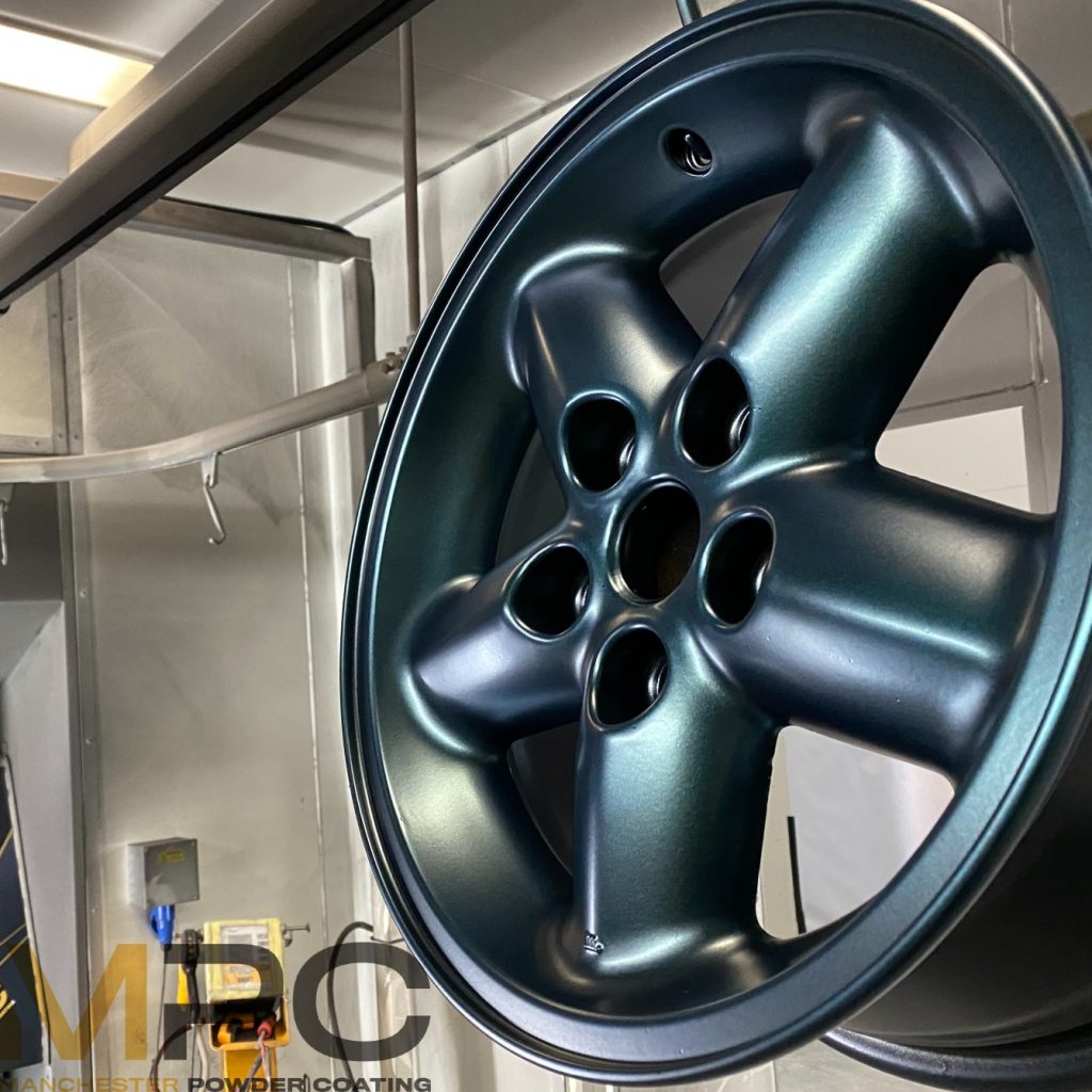 An image of a car alloy with a powder coating in a satin green colour